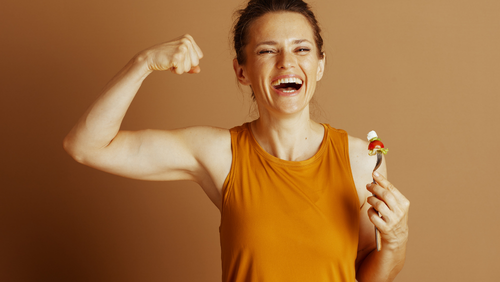 Woman in orange shirt flexing